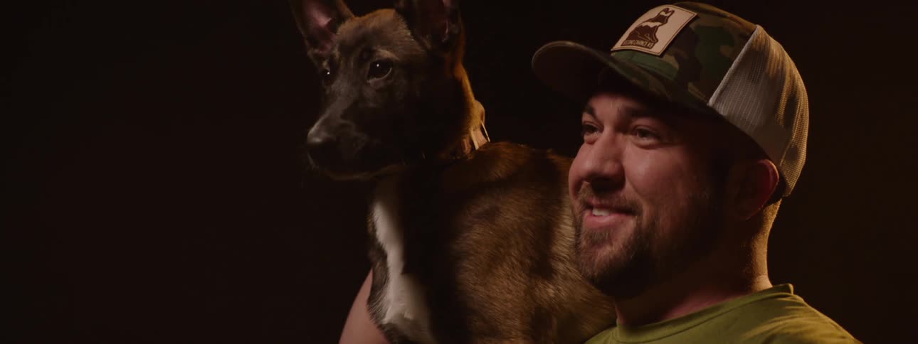Smiling man with a dog on his shoulder