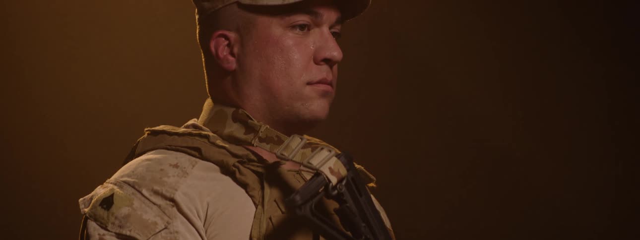 A solider stands while holding his gun