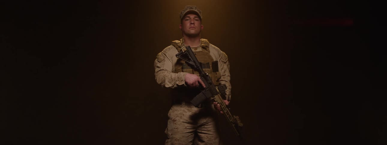 Soldier holding a weapon while in uniform in a lowlight environment