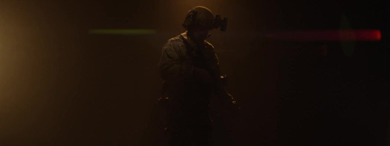 The video features a person in militarystyle camouflage fatigues holding a rifle with their face largely obscured by shadow the background is dark and smoky creating an intense and atmospheric scene that suggests a combat or tactical environment