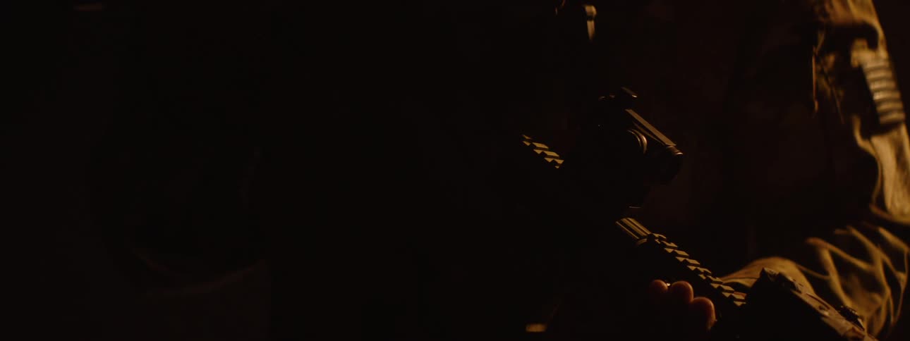 The video features a person in military fatigues largely in shadow with a distinct american flag patch visible on their tactical vest they are holding a rifle which gradually comes into view as the camera moves highlighting the weapon