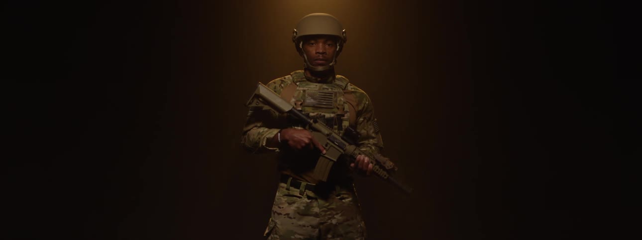 Military man with helmet and weapons in a lowlight space
