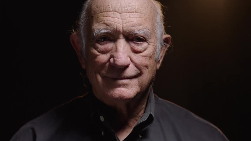 The elderly man looks up and smiles