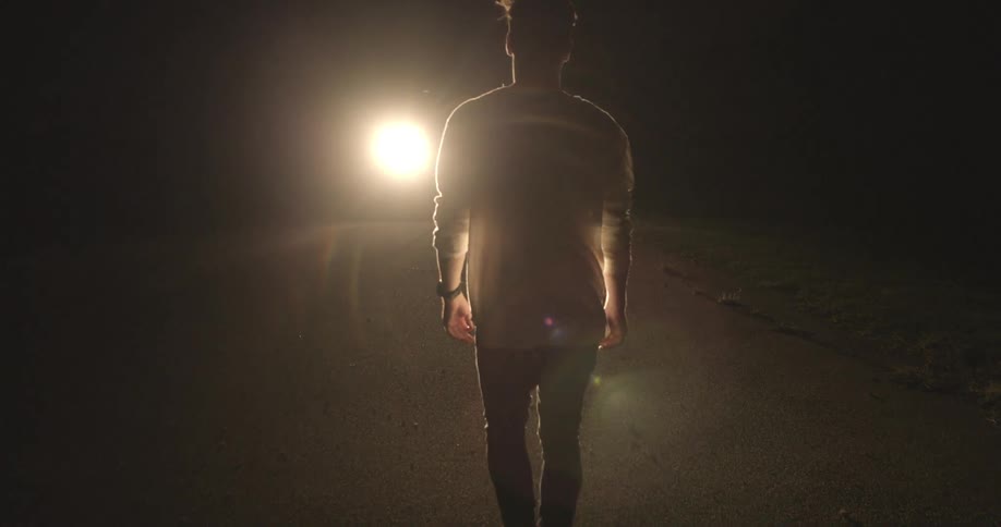 A person walking towards a light
