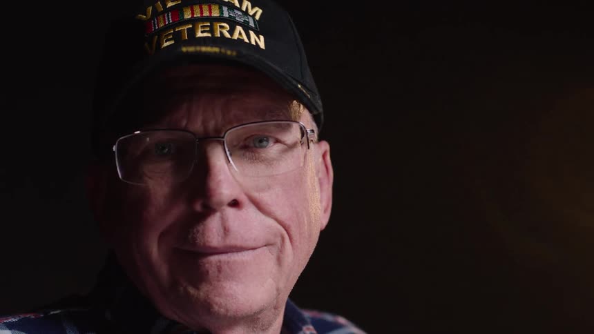 A veteran turns his head and smiles