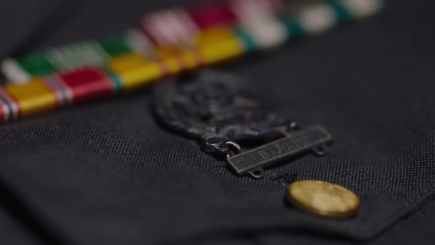 A badge is positioned on the front of a piece of clothing