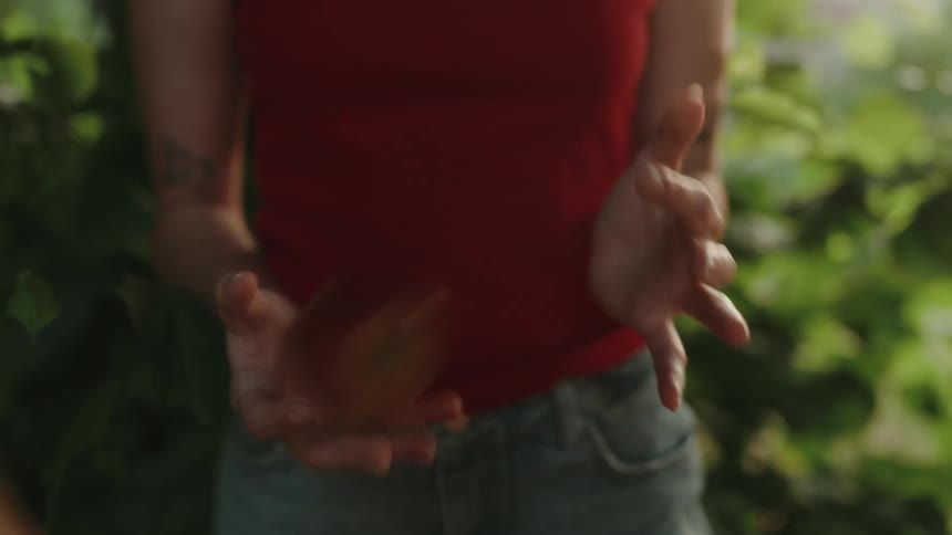 A woman plays with an apple