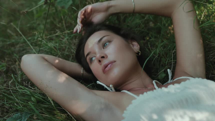 Woman in white dress lying on the grass