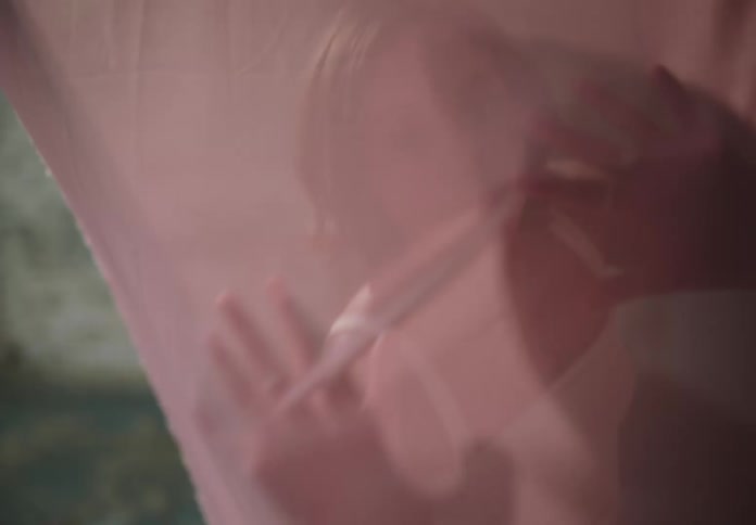 Woman moves dramatically under sheer fabric