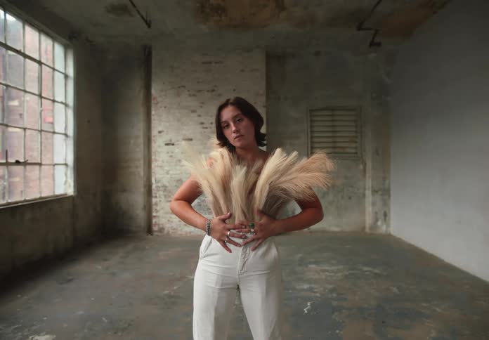 A model poses for a photoshoot in an empty room