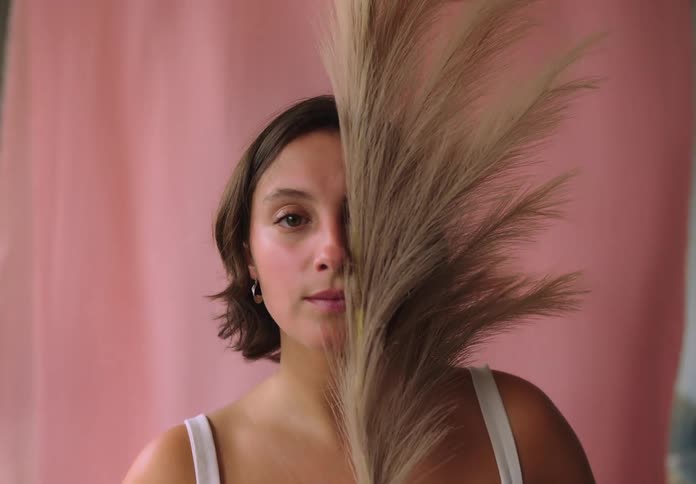 Woman with short hair with reed partially covering her face