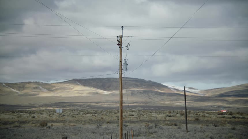 Truck passing through a mountainous landscape on a cloudy day