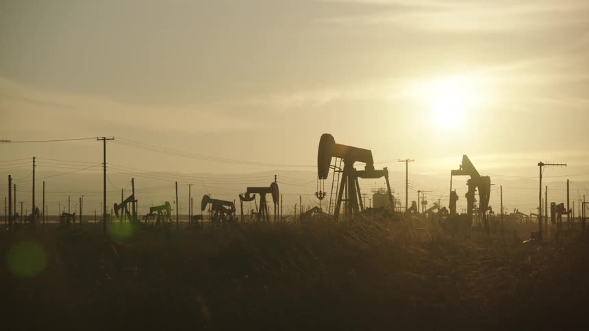 The sun is rising on the oil field