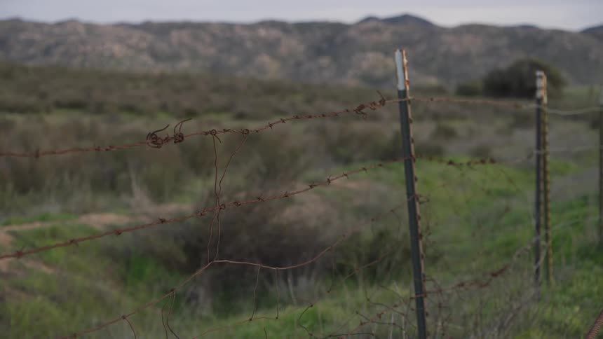 Barbed wire fence in the foreground stretching horizontally across the frame