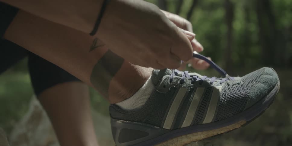 Person on a trail tying their shoelaces