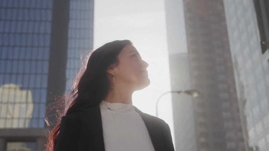 A woman stands outside in a city