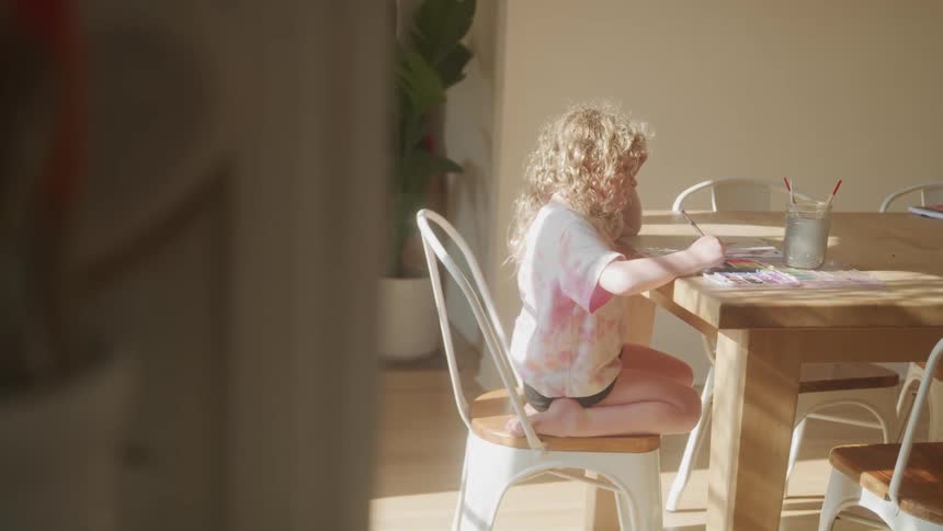 Girl sitting at a table drawing