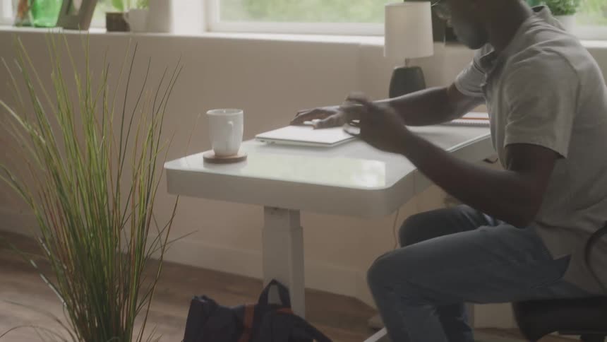 Man sitting at a table and opening laptop