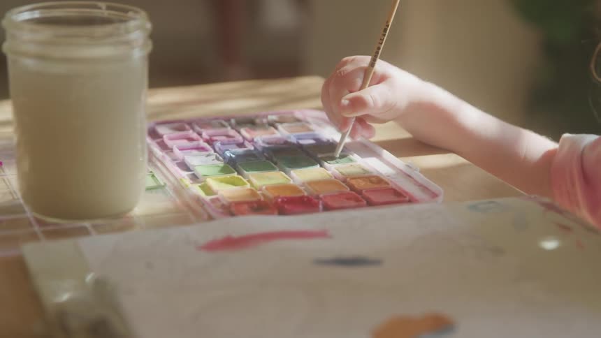 The child is using a paint brush