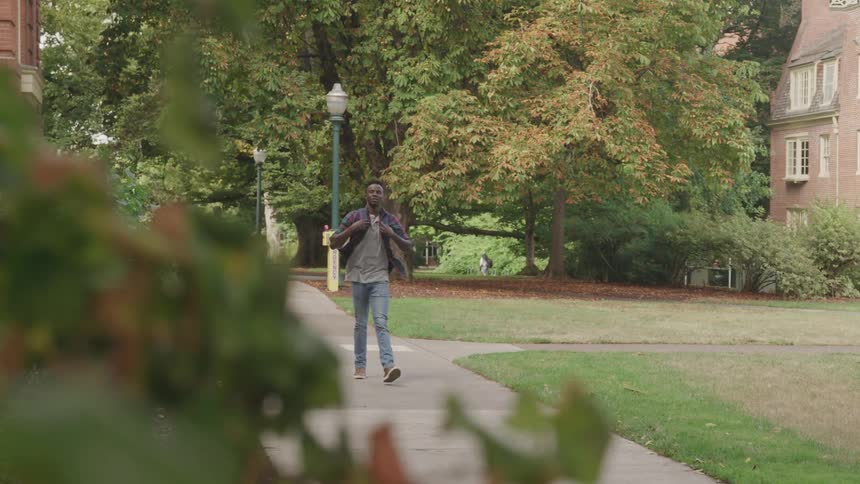 Man with a backpack walking outdoors in an urban area