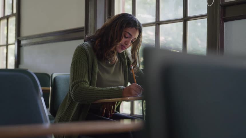 Woman sitting at a small table writing