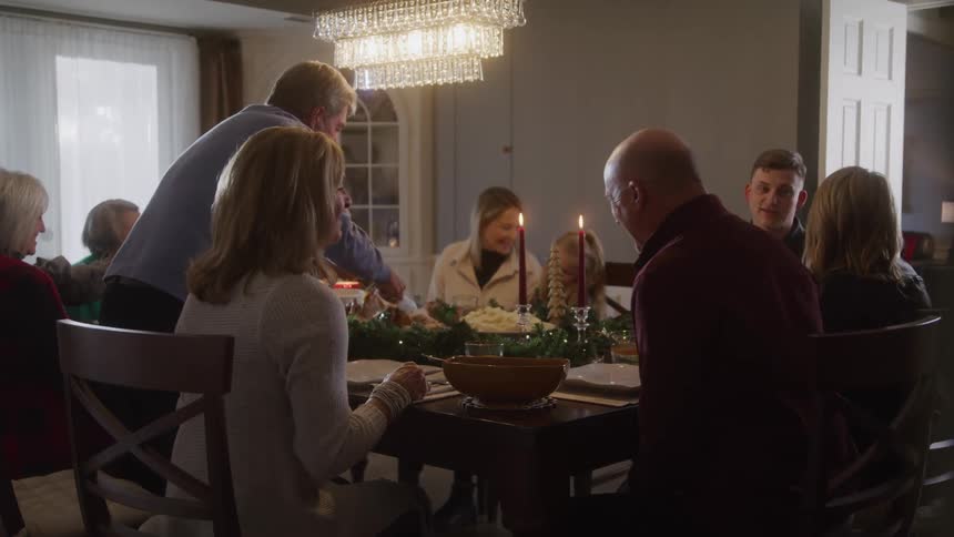 Happy family gathered at a dinner table with food and candles