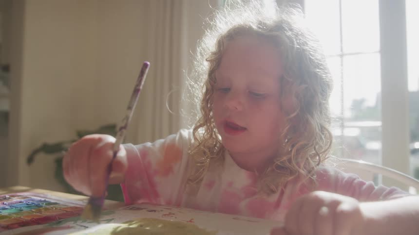 The girl talks while painting