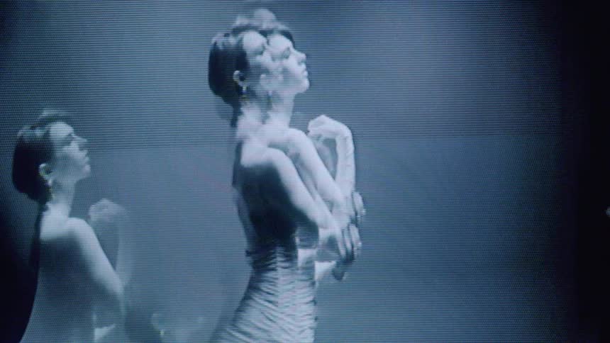 A woman models a dress in black and white on a screen