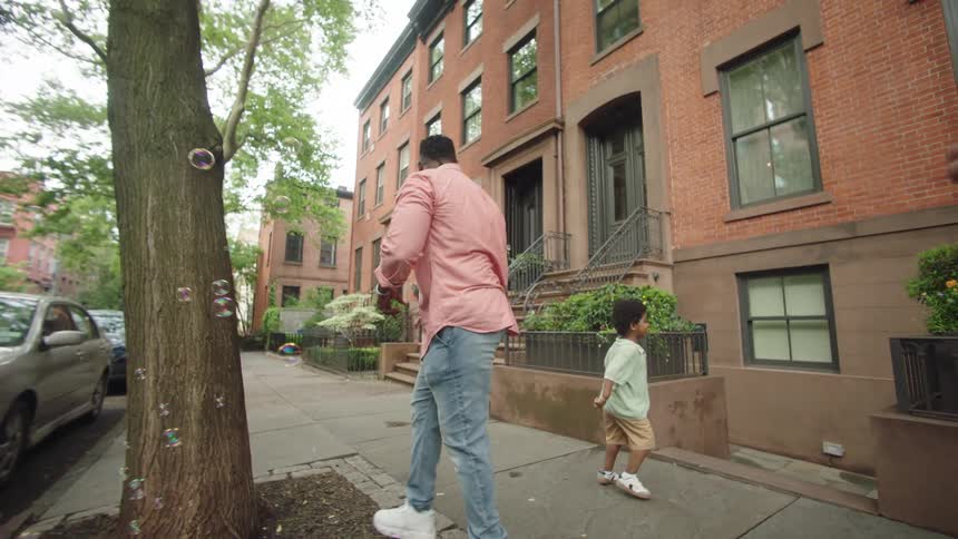 A mother blows bubbles as the child plays