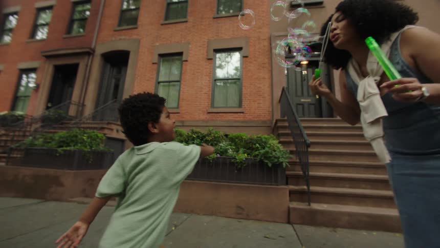 A mother blows bubbles for her son