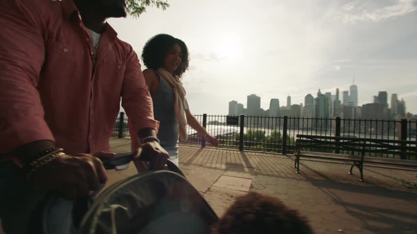 A family walks through the park by the city
