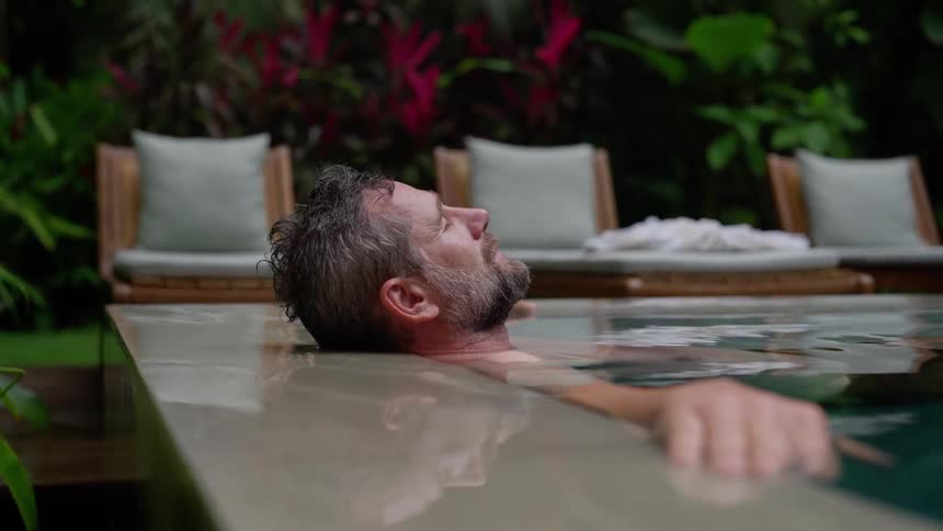 Man relaxes in a tropical pool