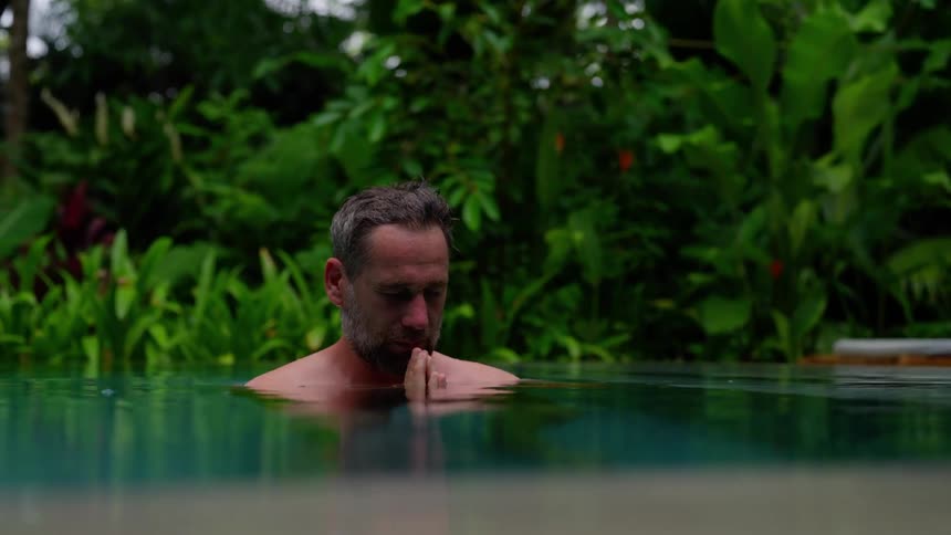 Man with palms together diving into a swimming pool