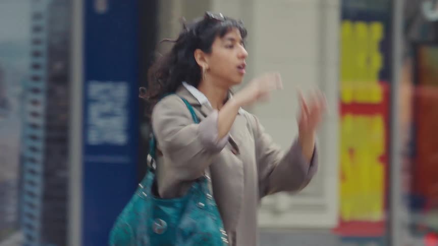 Woman walking quickly through the city and making a negative sign with her finger