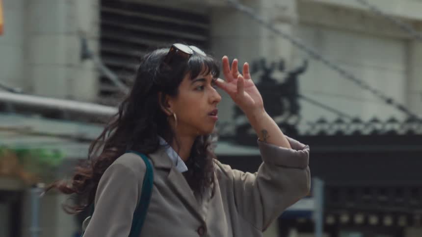 Young woman walks along a busy city street during daytime
