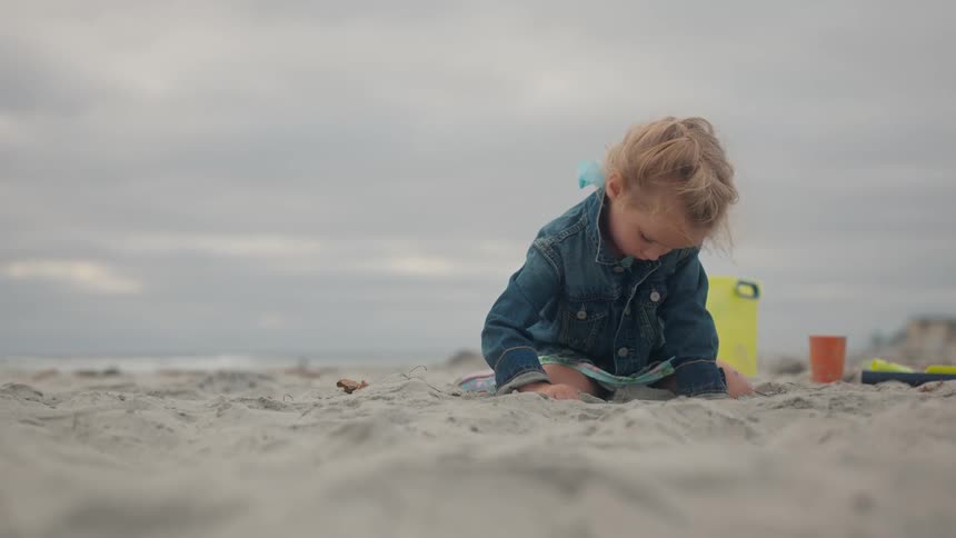 The girl flings sand with the shovel