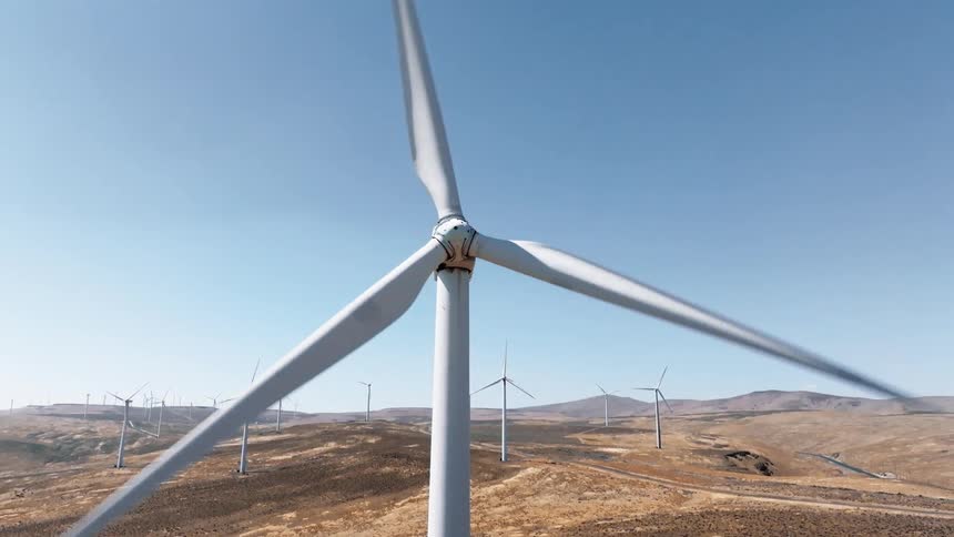 Wind turbine in operation against a clear blue sky