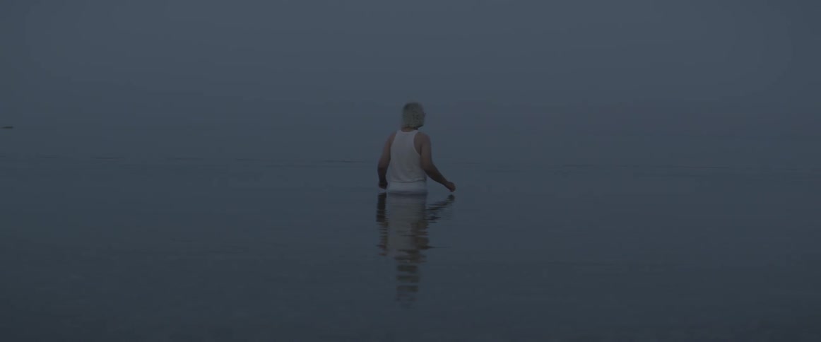 A man wades through waist deep water