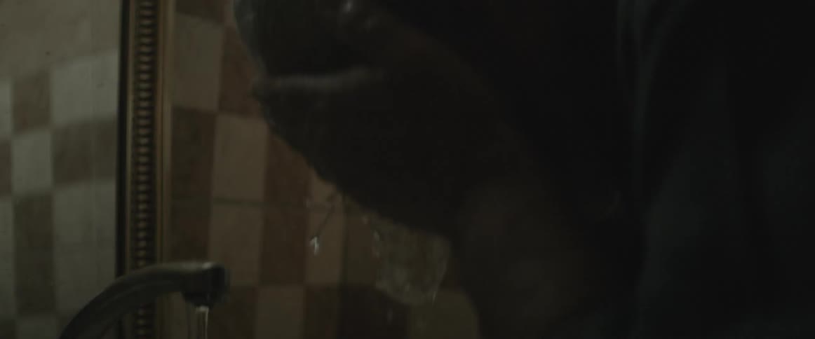 A man washes his face at the sink