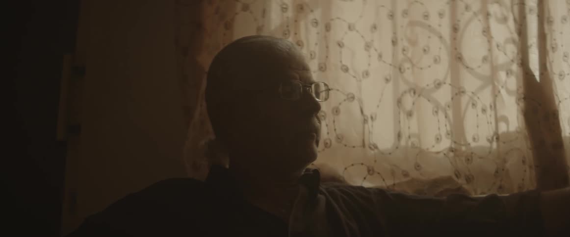 Man sitting by window in dark room