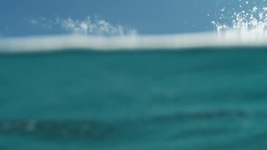 A large wave crashes over the camera