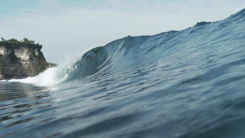 Ocean wave forms and crashes along the ocean surface during daytime