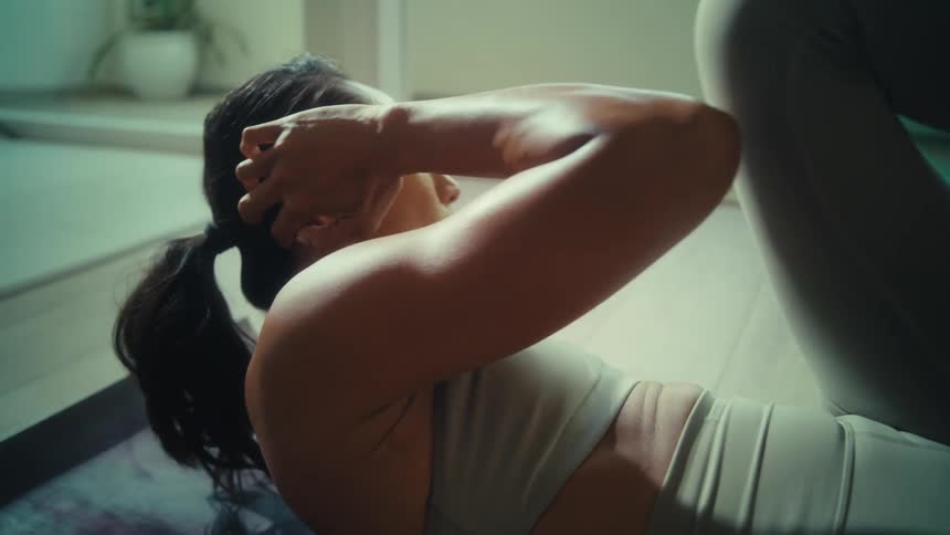 A young woman indoors doing situp exercises