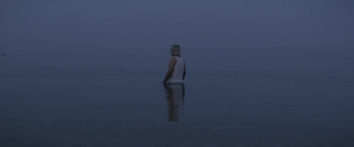 A man wades through waist deep water