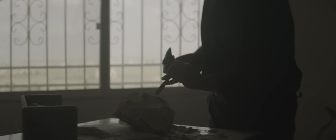 A man works with a hammer and chisel