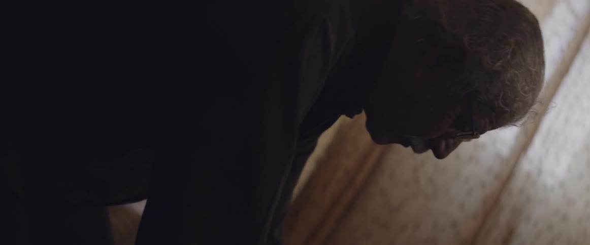 A man is praying in a dark room