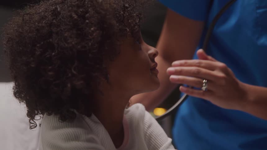 Young child looks up during checkup by healthcare worker