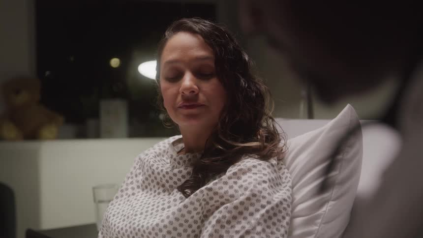 Female patient in a hospital room talking to a person