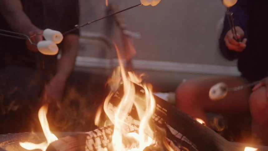 People roasting marshmallows over a fire