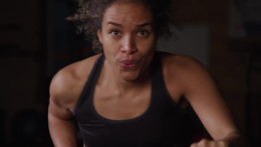The woman is pedaling on the exercise bike